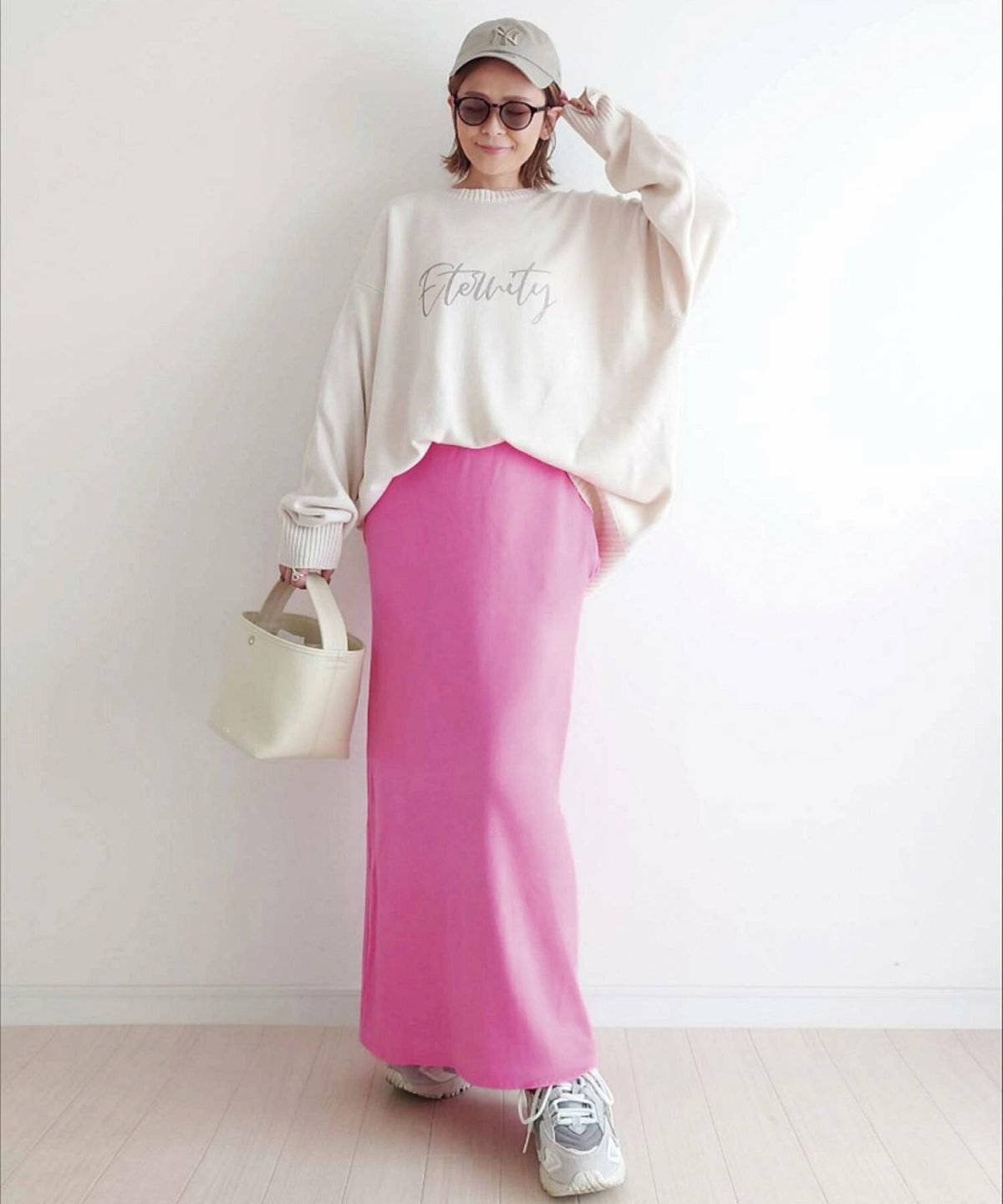 白トップスにピンクのスカートを合わせた女性