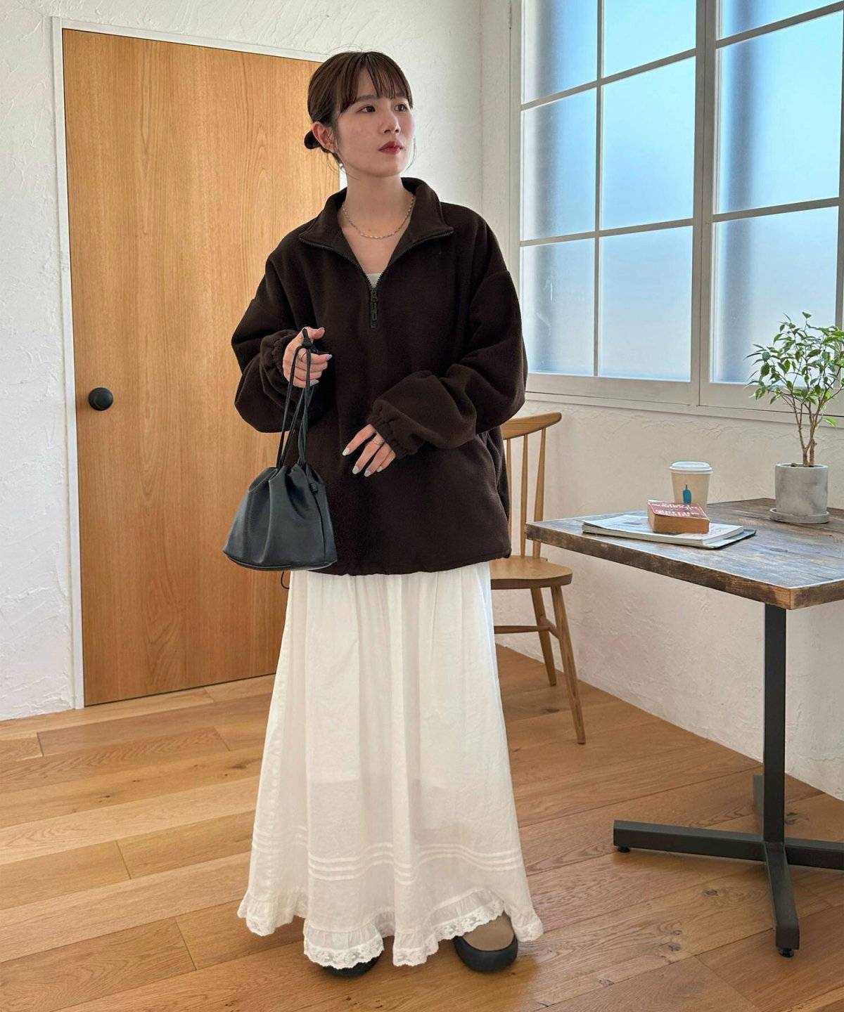 ブルゾンに白スカートを合わせた女性