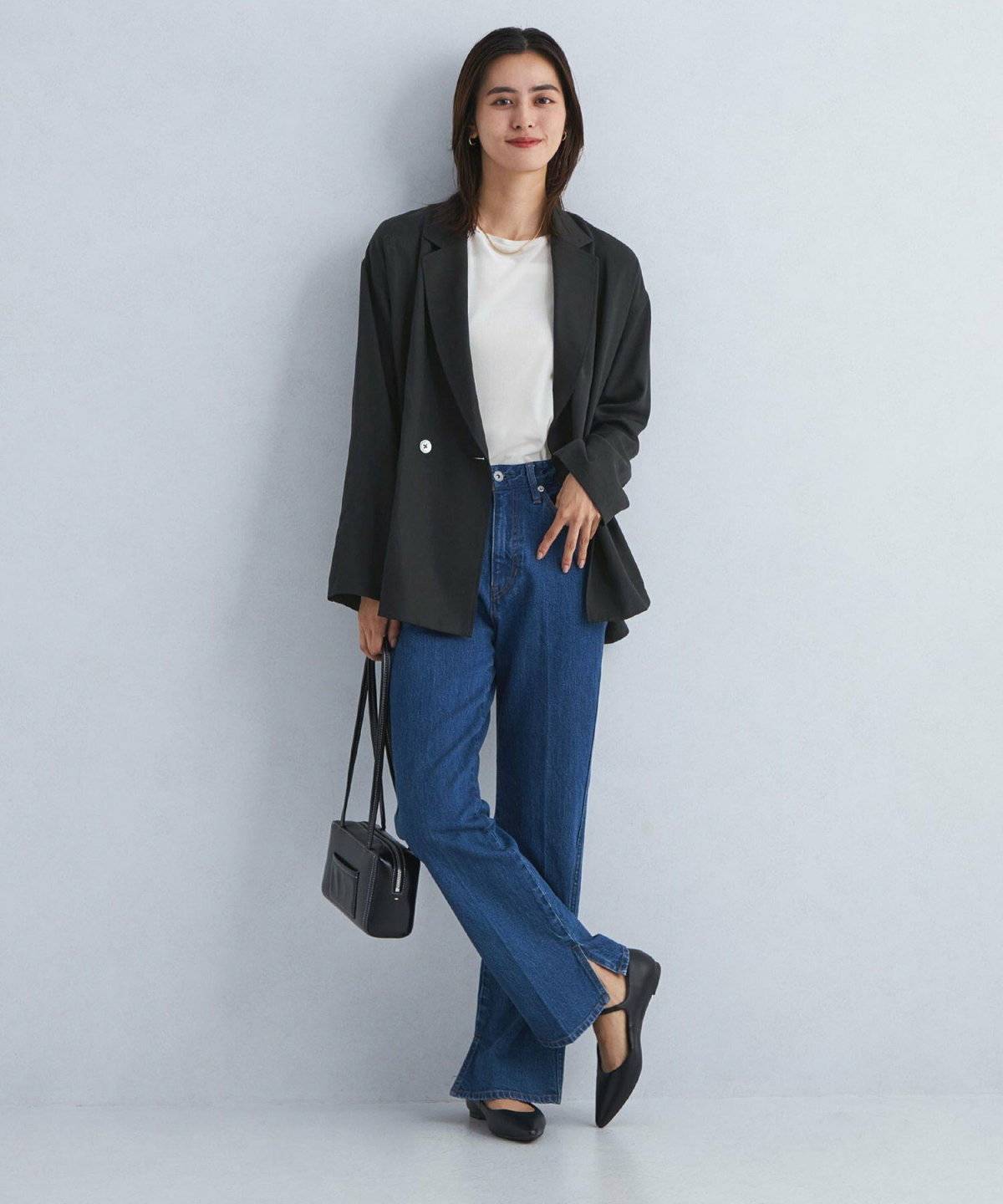 白Tシャツに黒ジャケットを羽織ってデニムを合わせた女性