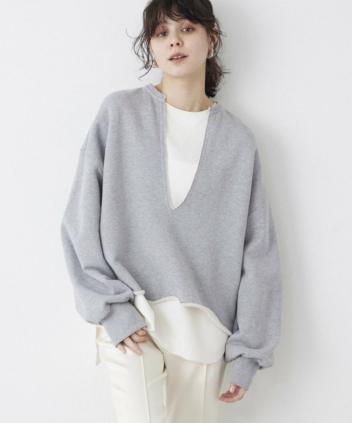 グレーのスウェットに白パンツを合わせた女性