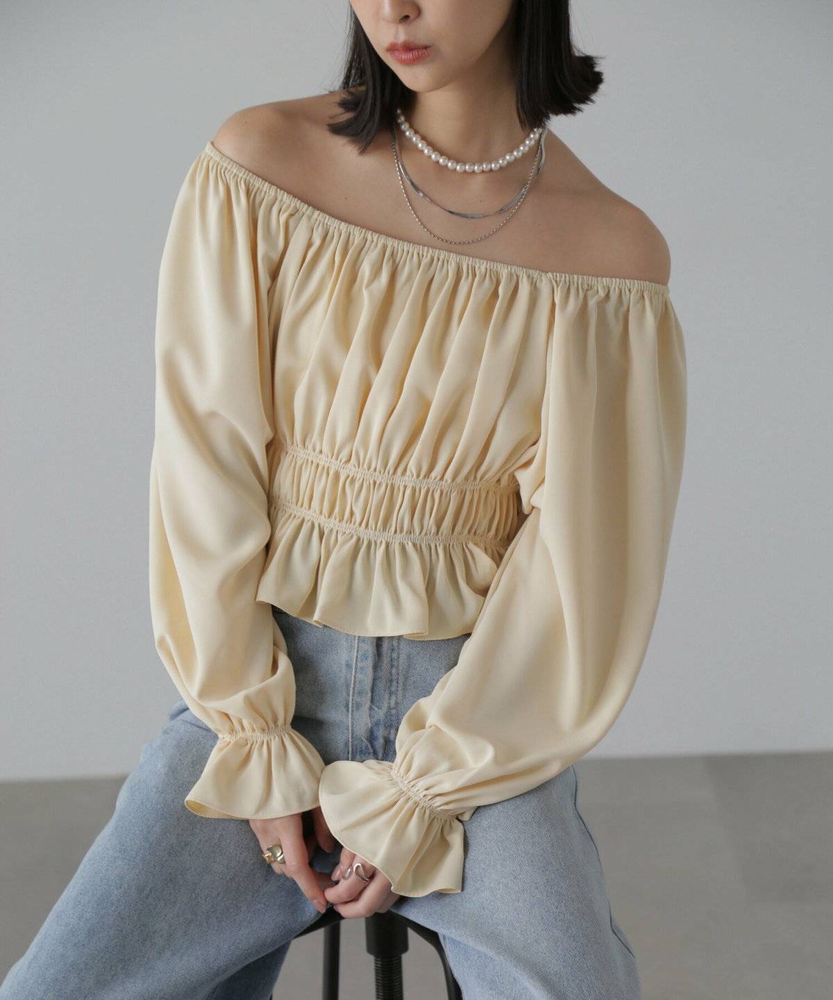 ブラウスにデニムを合わせた女性