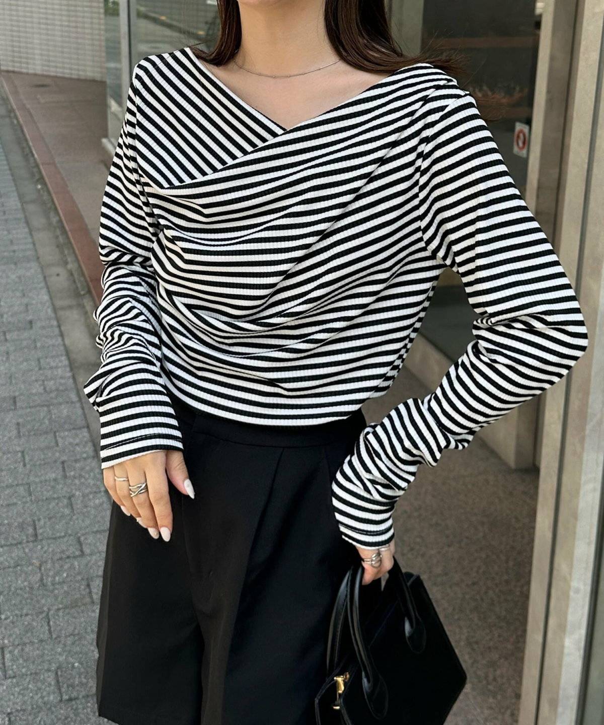 ブルーのボーダー柄トップスにパンツを合わせた女性