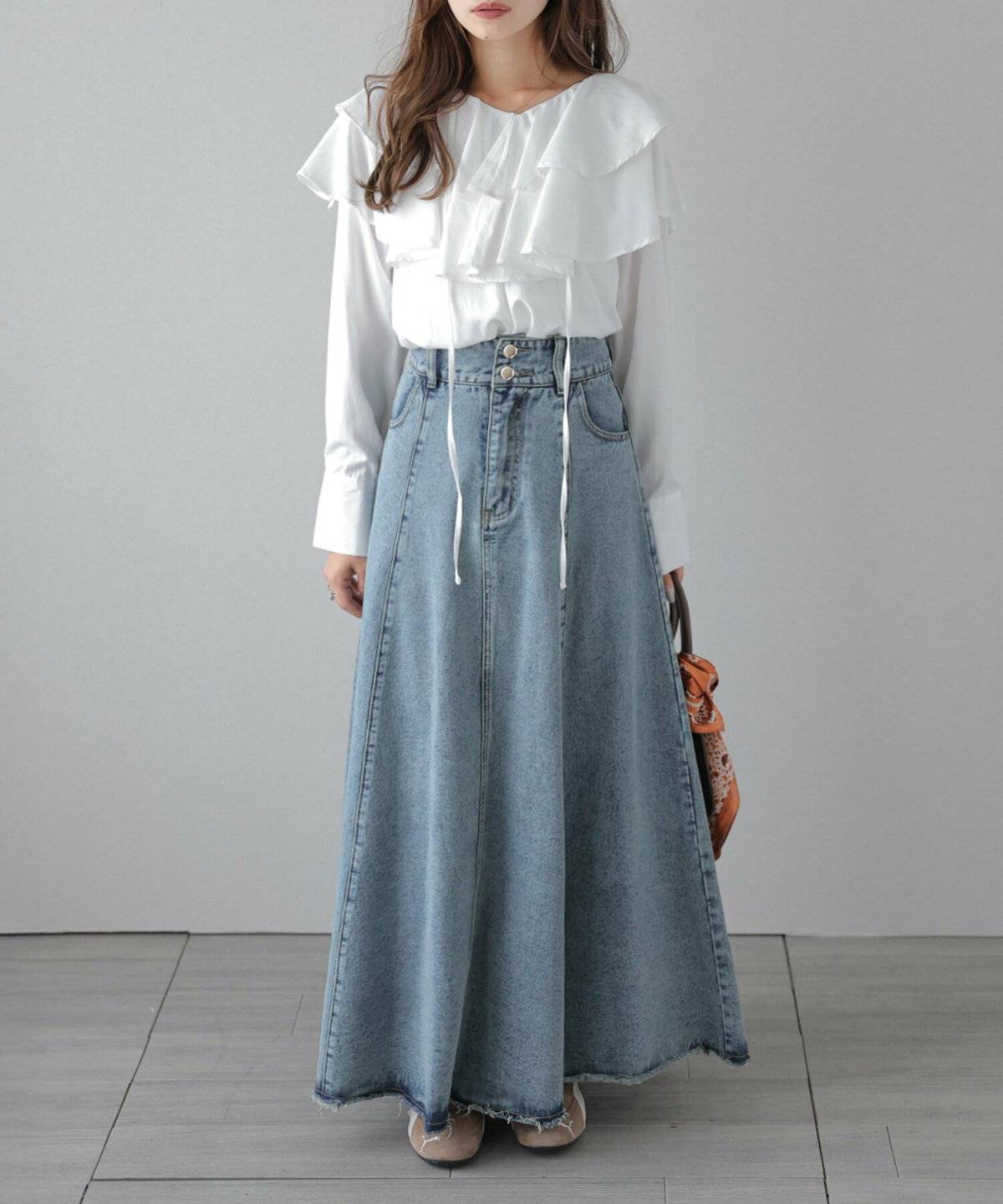 白トップスにデニムスカートを合わせた女性