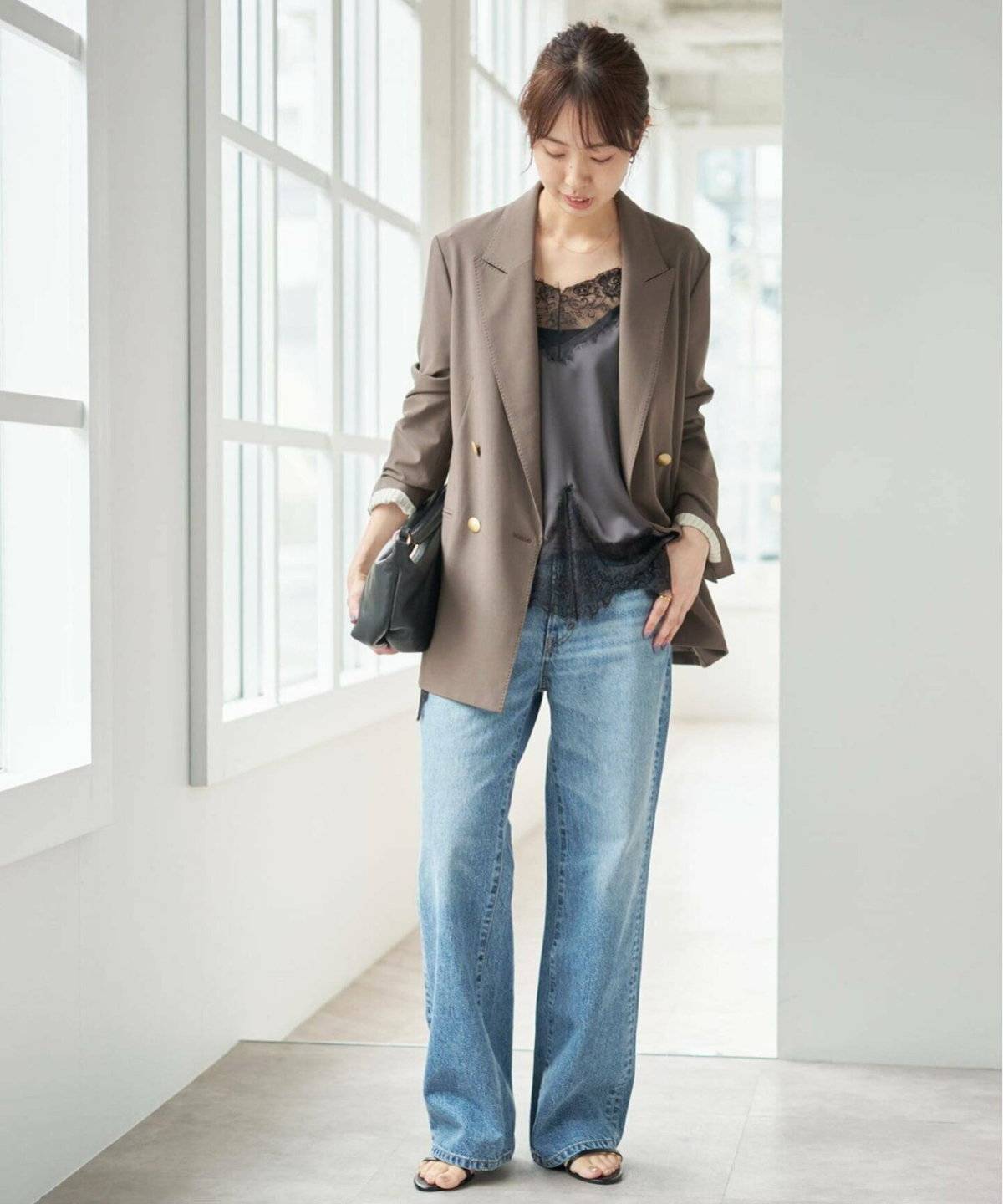 キャミソールにジャケットを羽織ってデニムを合わせた女性
