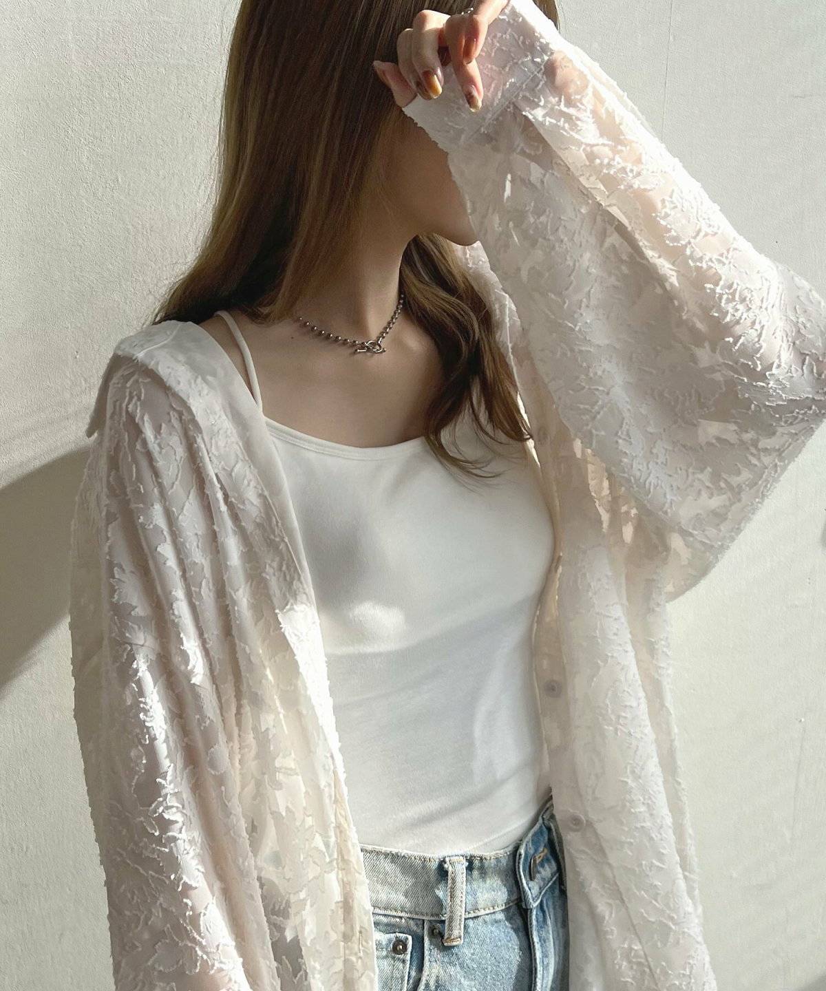 白トップスにデニムを合わせた女性