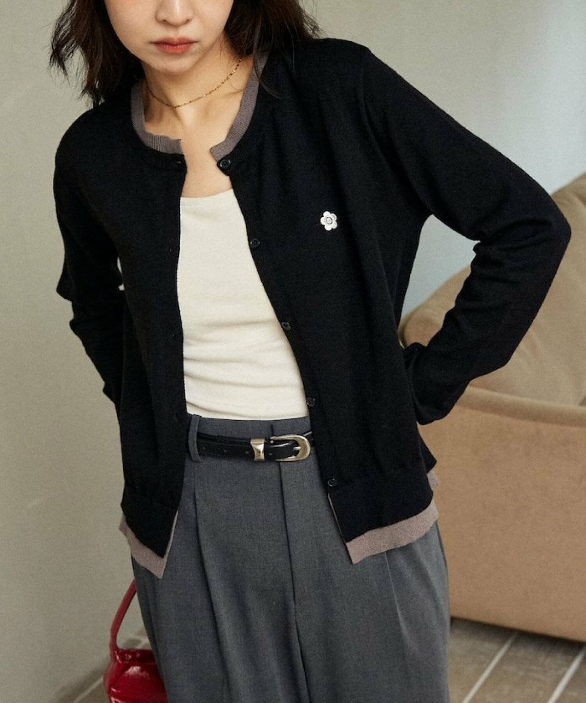 黒カーディガンにグレーのパンツを合わせた女性