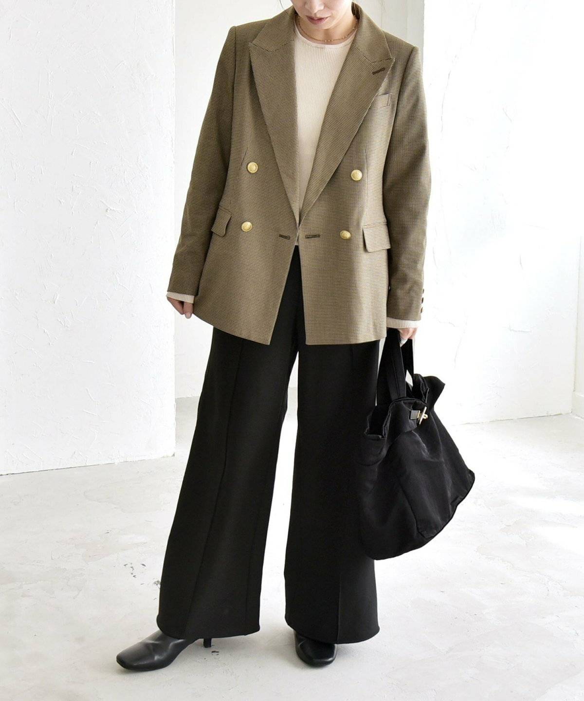 ベージュのジャケットにパンツを合わせた女性