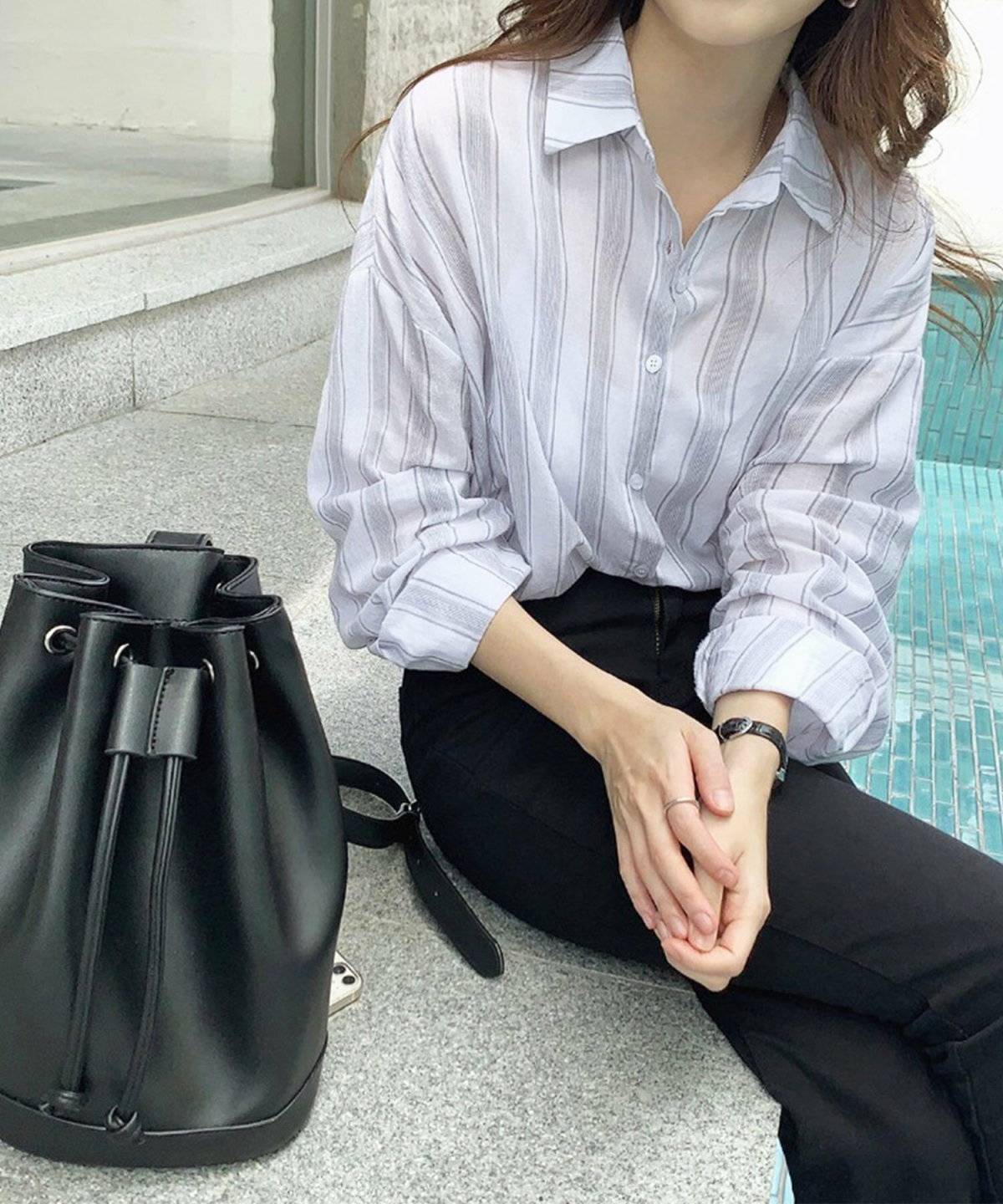 ブラウスに黒パンツを合わせた女性