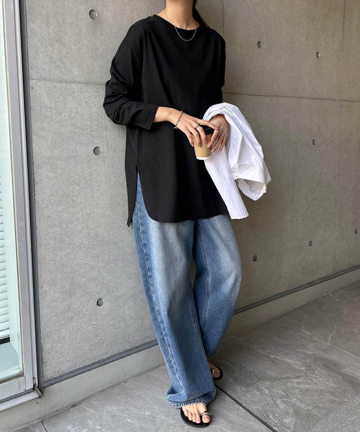黒トップスにデニムを合わせた女性