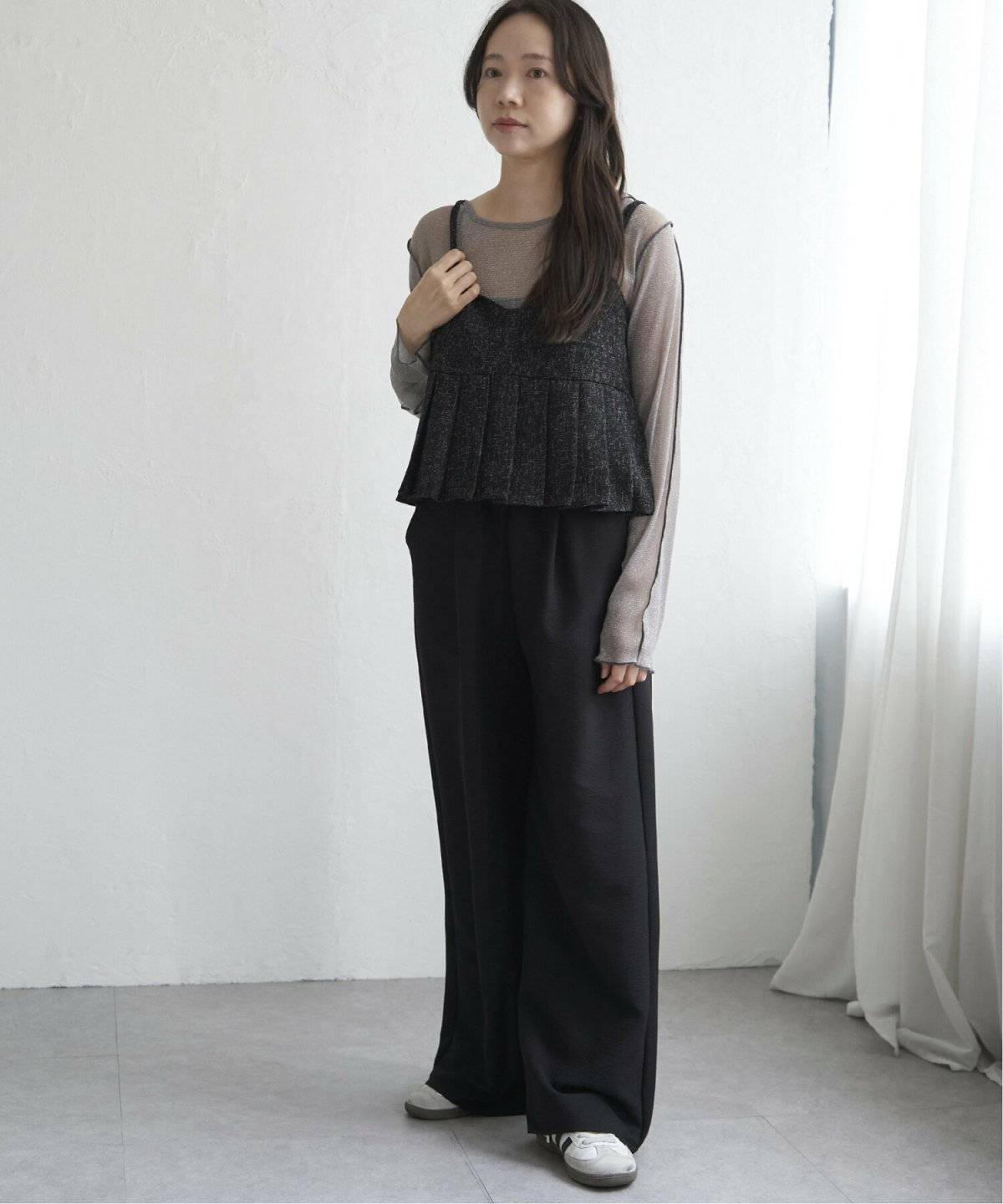 ツイードトップスに黒パンツを合わせた女性