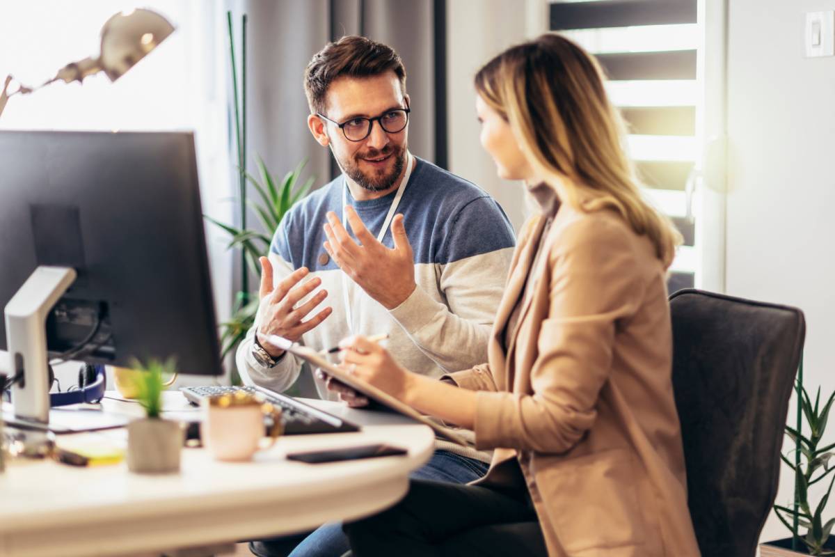 デスクで話し合う男女