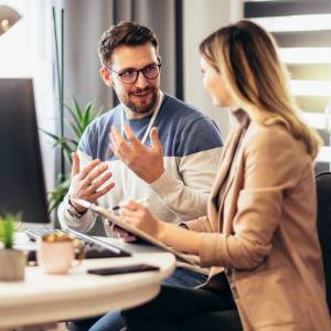  デスクで話し合う男女 