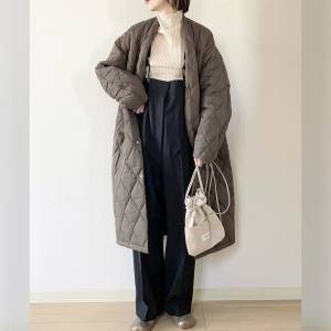  モノトーンコーデの上にブラウンのコートを羽織った女性 