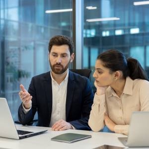  パソコンを見ながら話し合う男女 