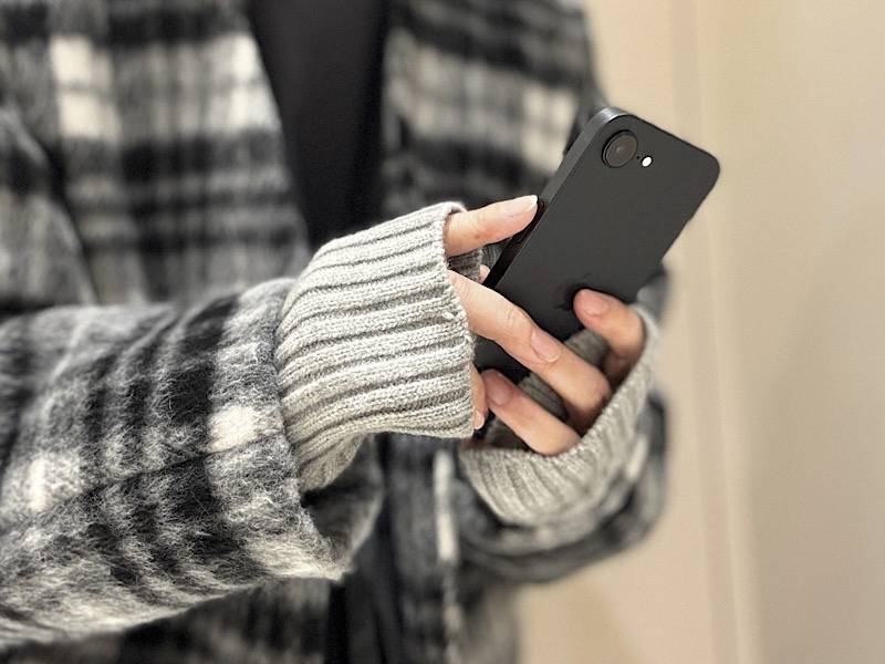 アームウォーマーとコートを合わせている女性の手元