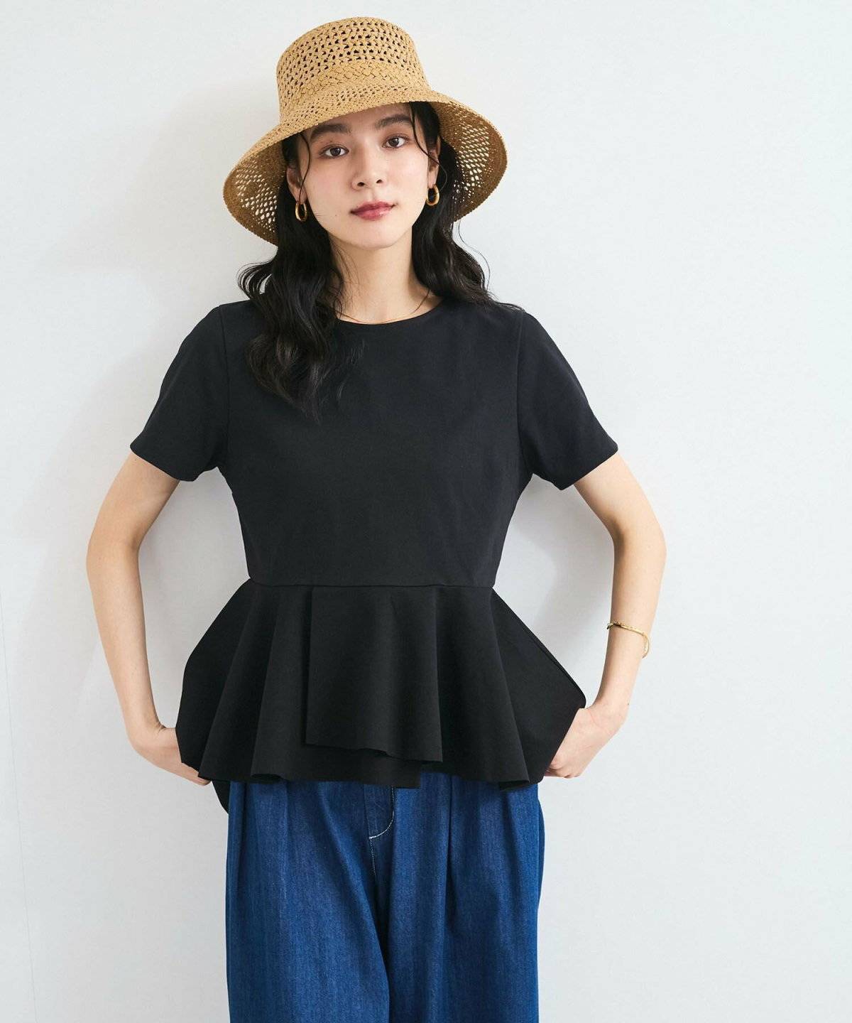 黒トップスにカラーパンツを合わせた女性