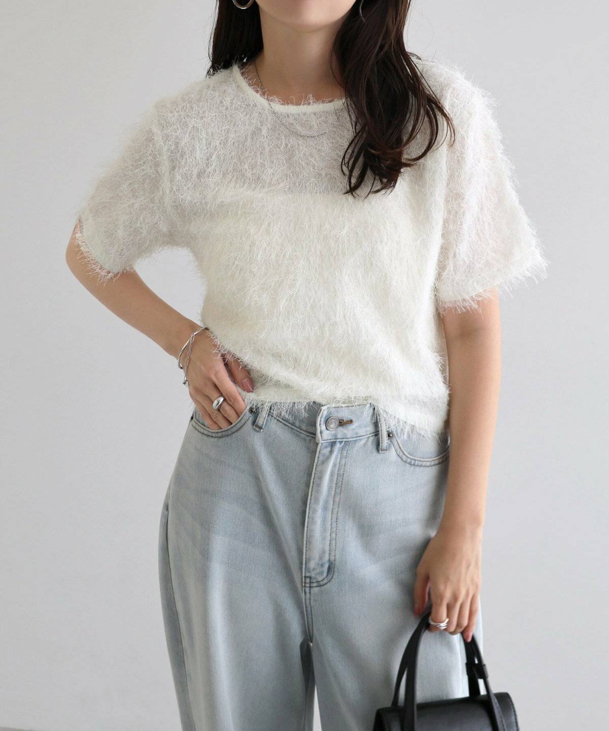 白キャミソールにデニムを穿いた女性