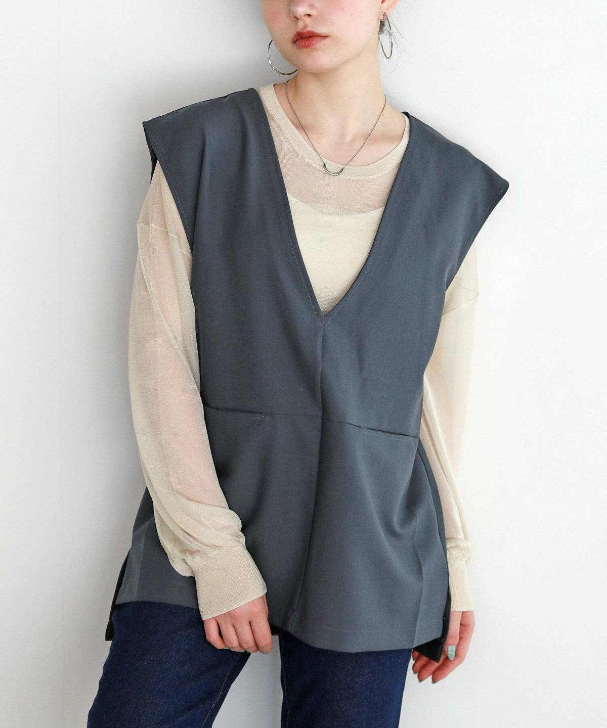 黒ベストにデニムを合わせた女性