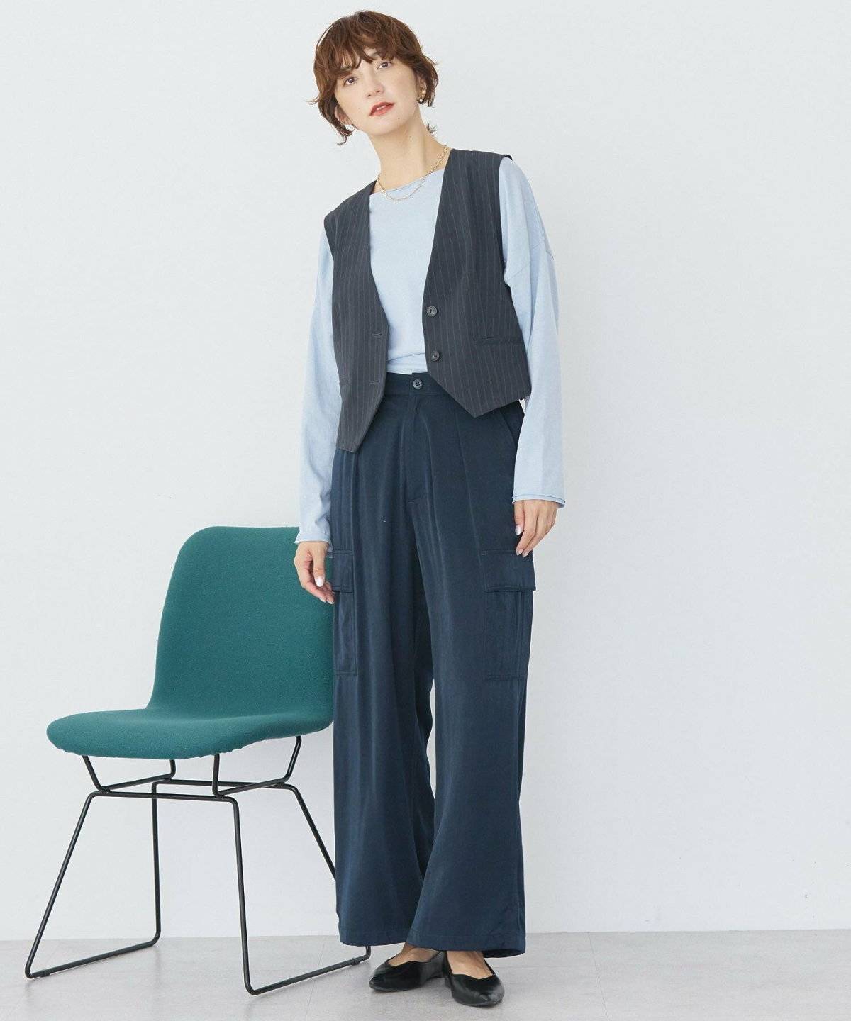 ロングTシャツにベストを重ねてデニムを合わせた女性