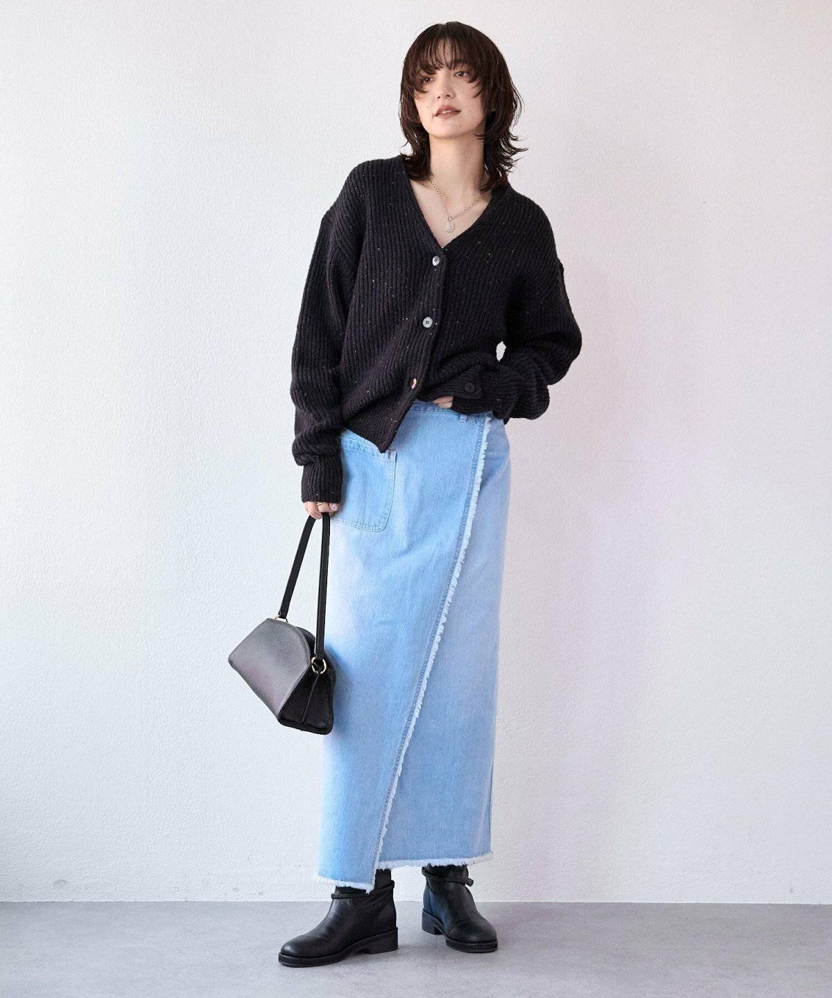 黒トップスにデニムスカートを合わせた女性