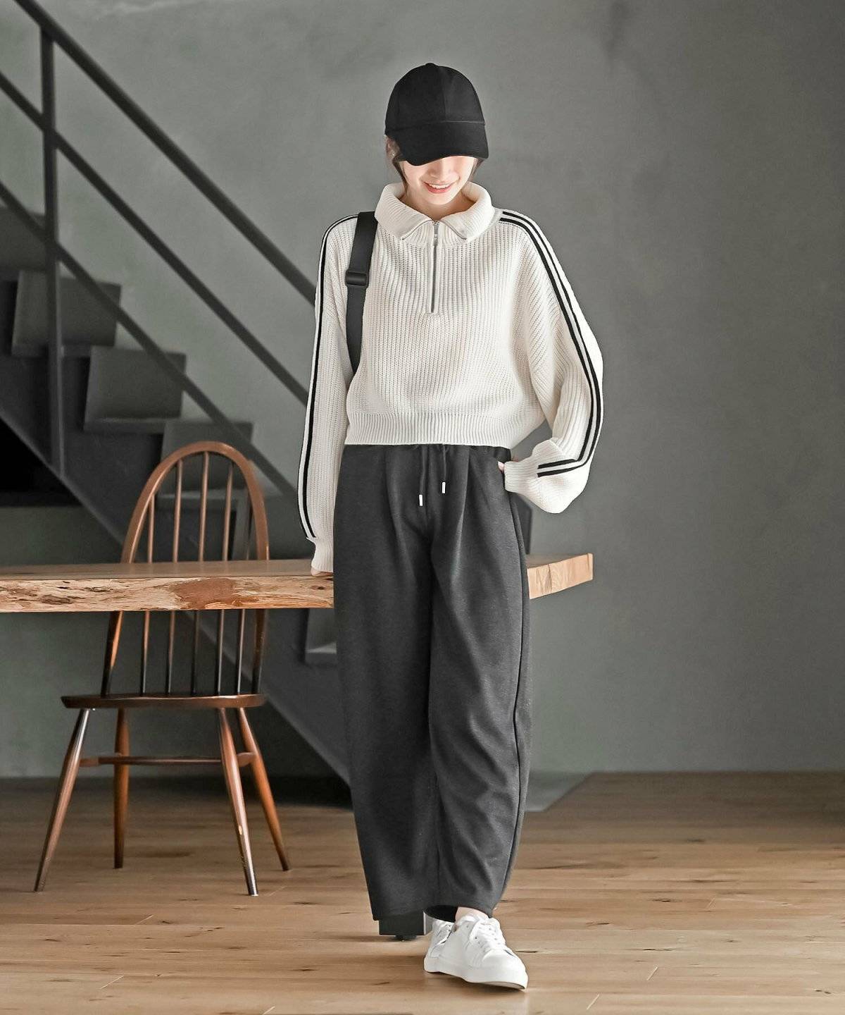 白ニットに黒パンツを合わせた女性