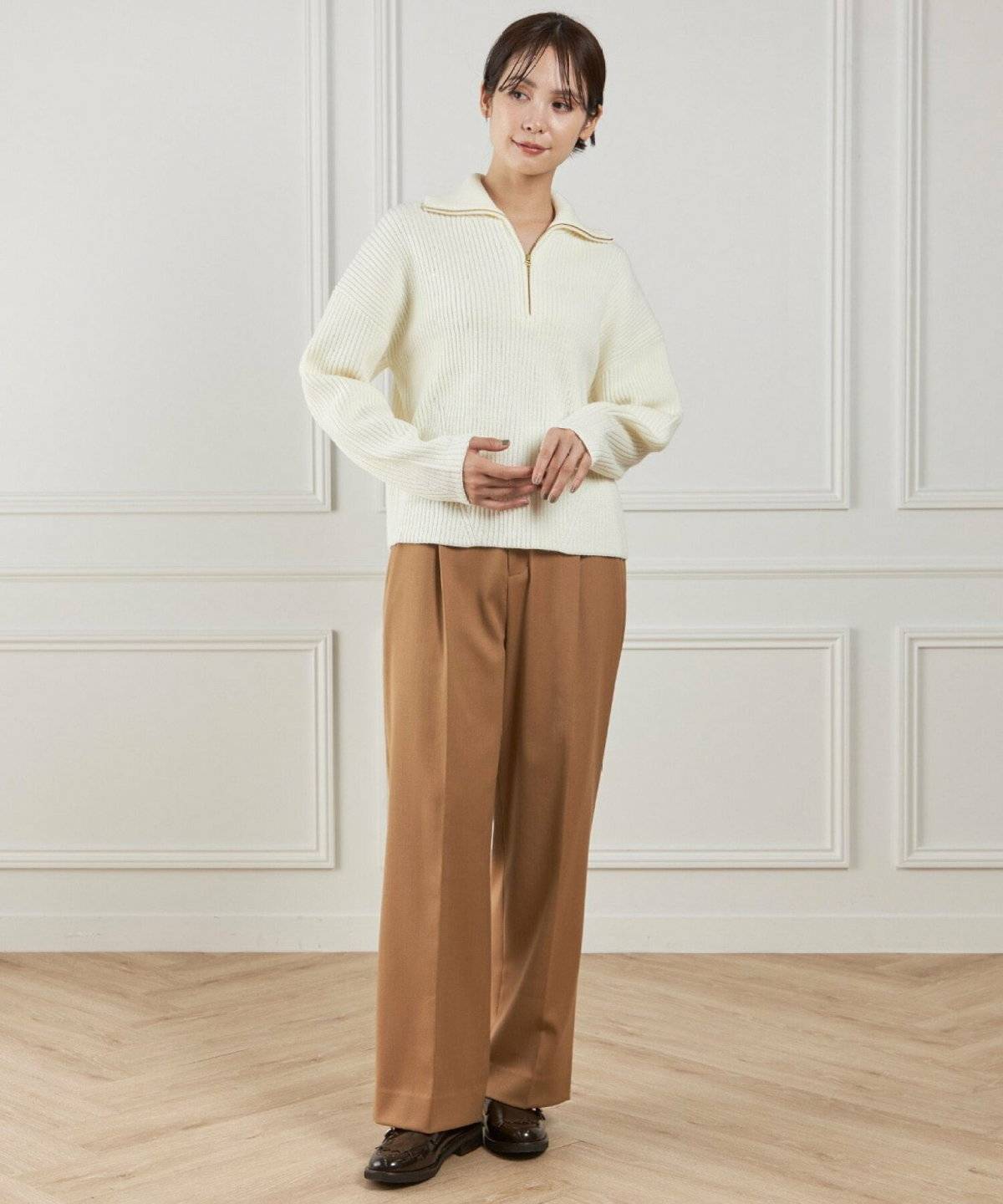 白ニットにグレーパンツを合わせた女性