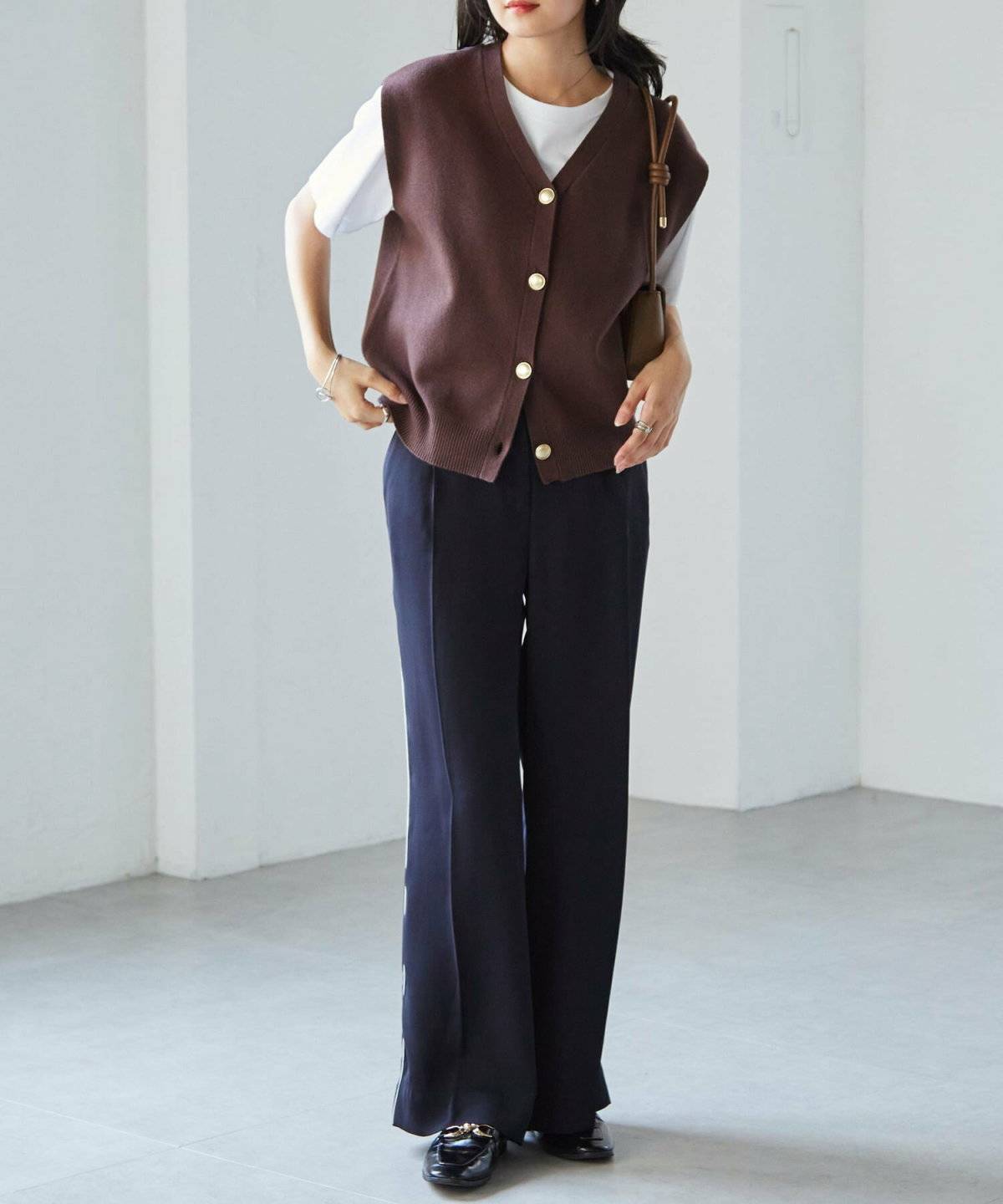 モノトーンコーデにブラウンのベストを重ねた女性