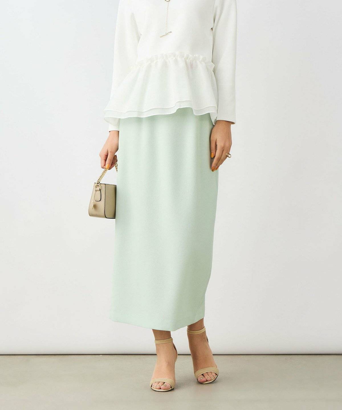 ミントグリーンのスカートを履いた女性