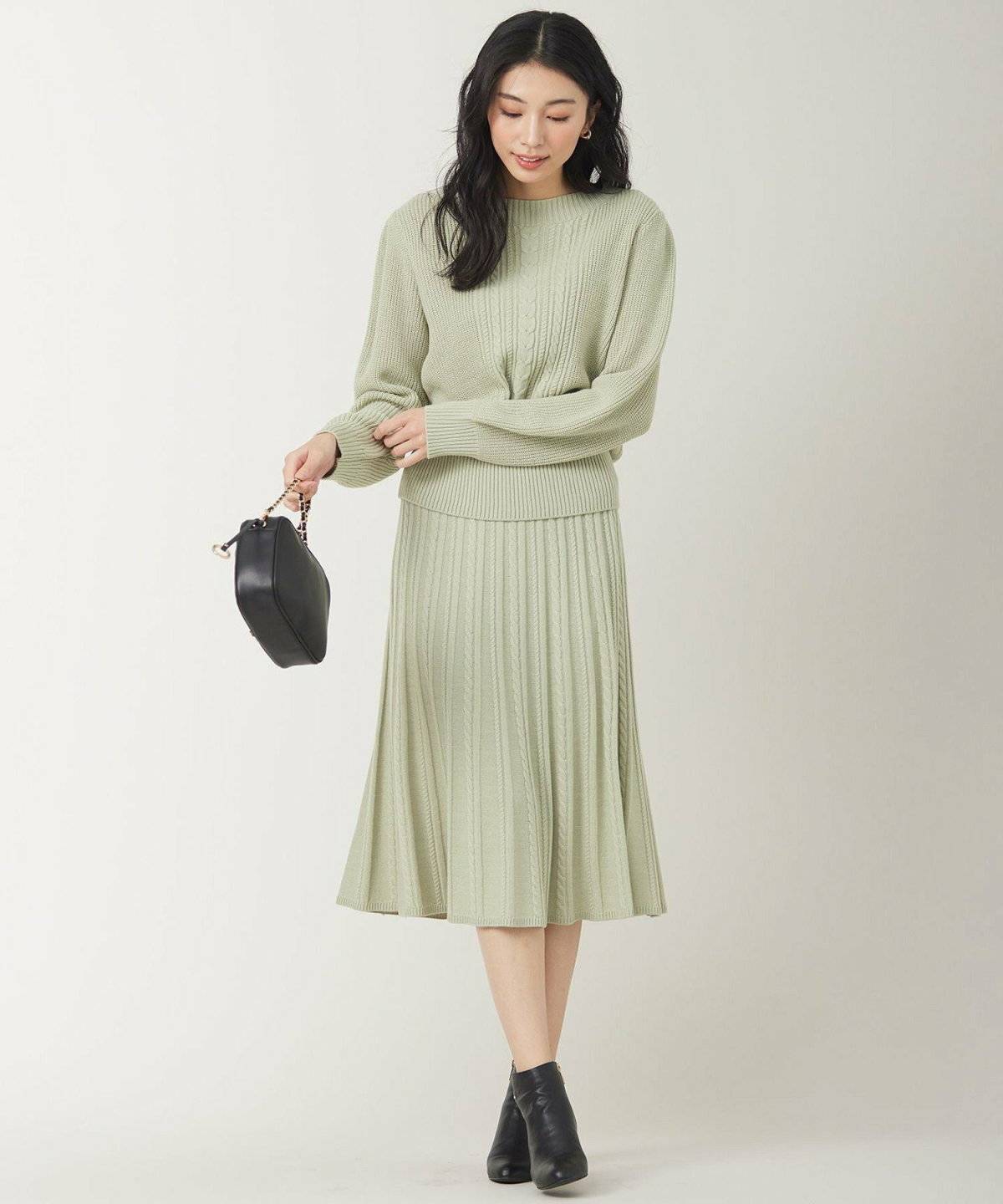 ミントグリーンのスカートを履いた女性