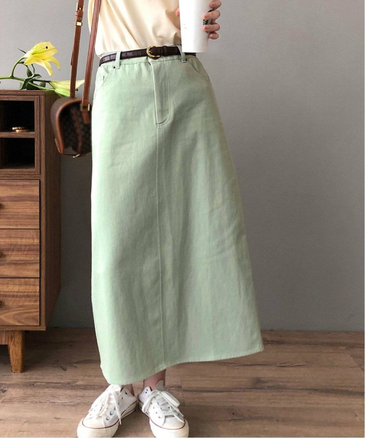 ミントグリーンのスカートを履いた女性