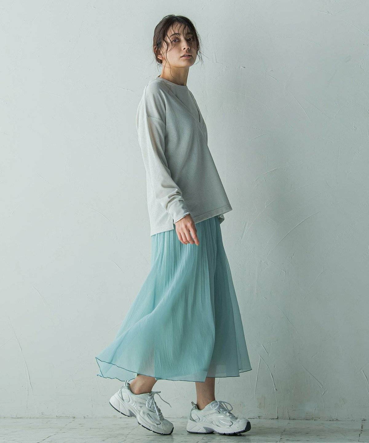 ミントグリーンのスカートを履いた女性