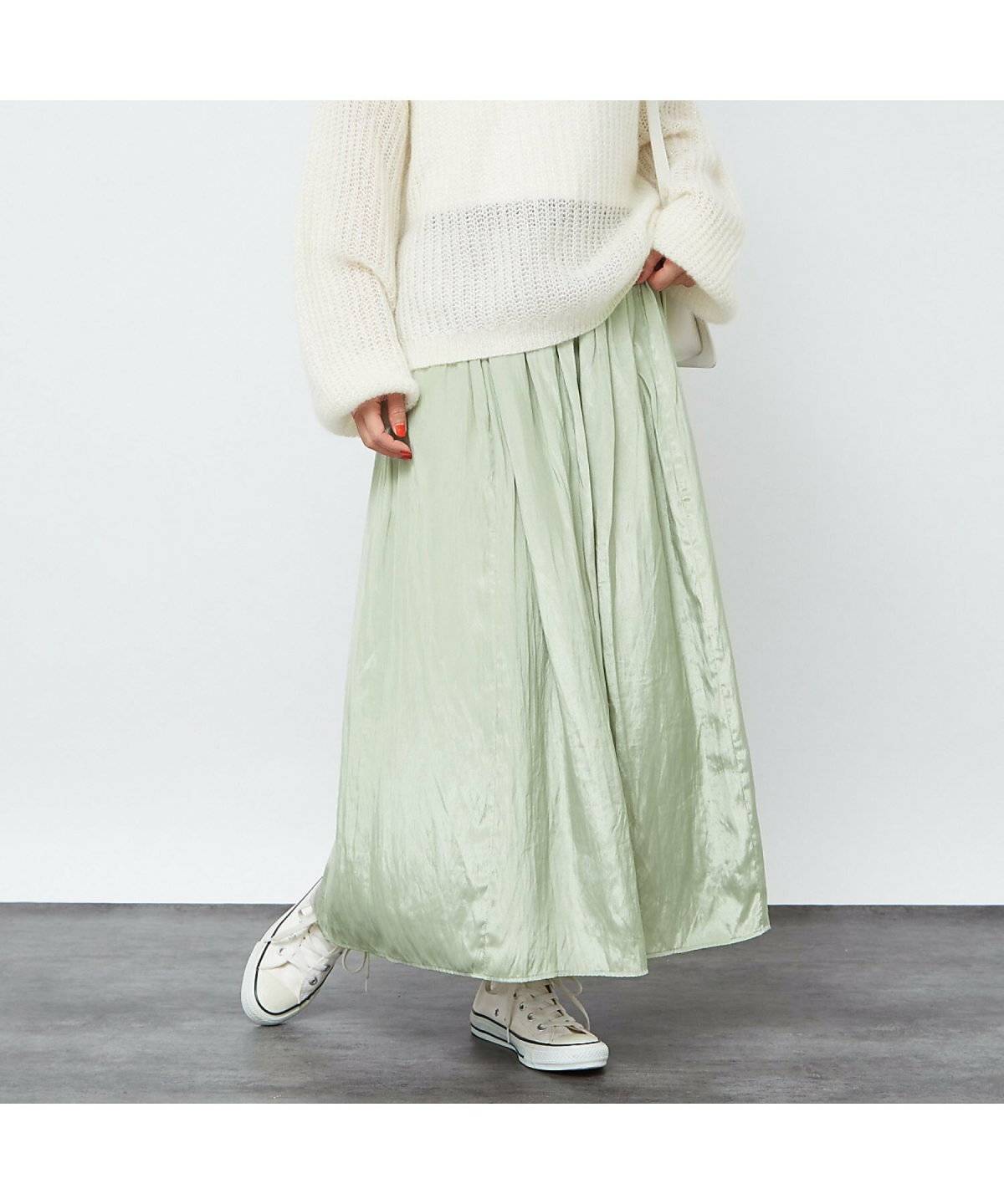 ミントグリーンのスカートを履いた女性