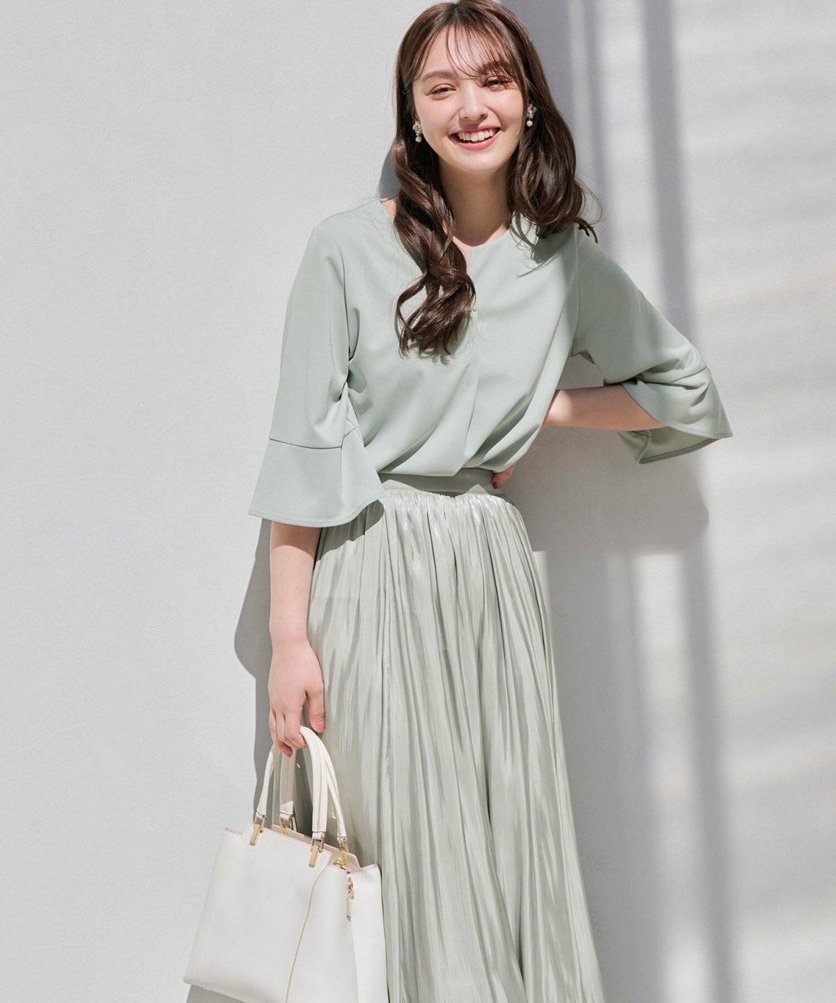 ミントグリーンのスカートを履いた女性