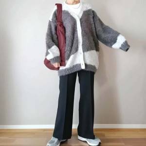  柄カーディガンに黒パンツを合わせた女性 