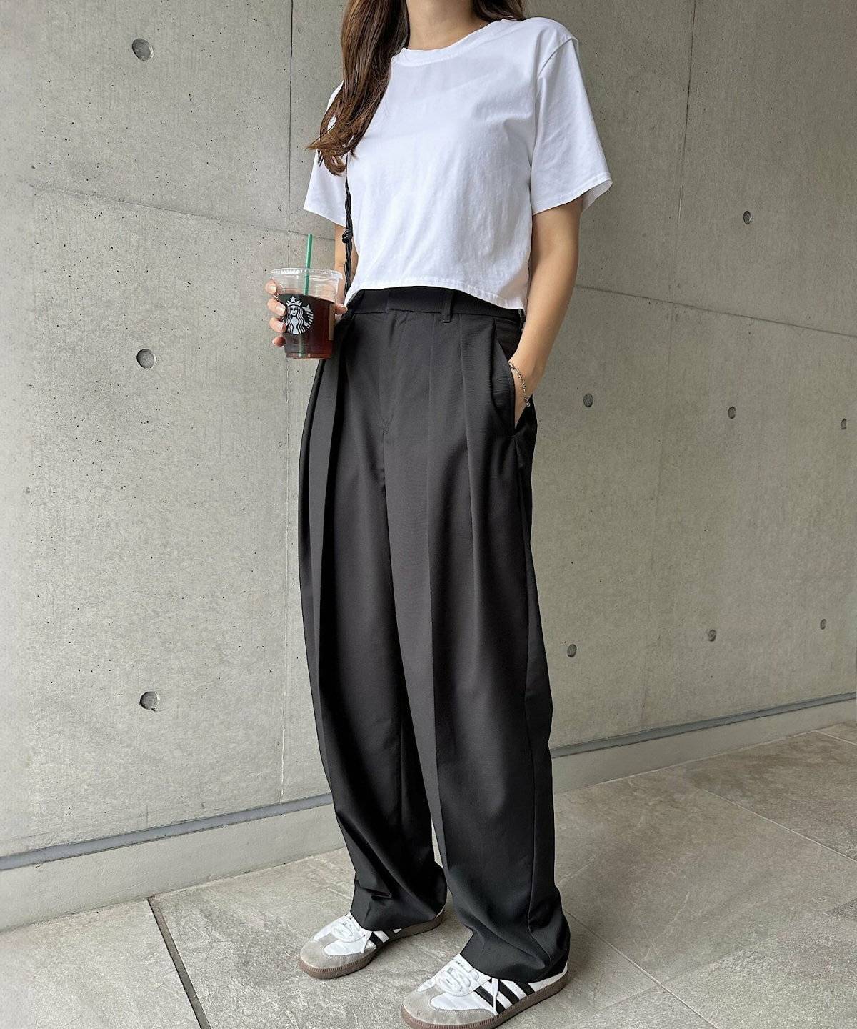 Tシャツにグレーのスラックスを合わせた女性