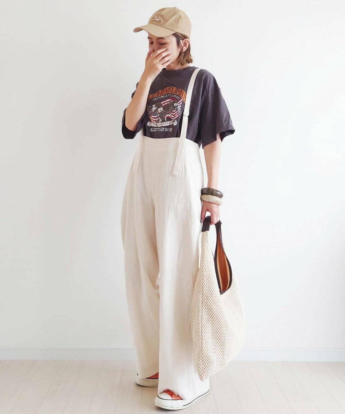 グレーのTシャツに白のサロペットを合わせた女性