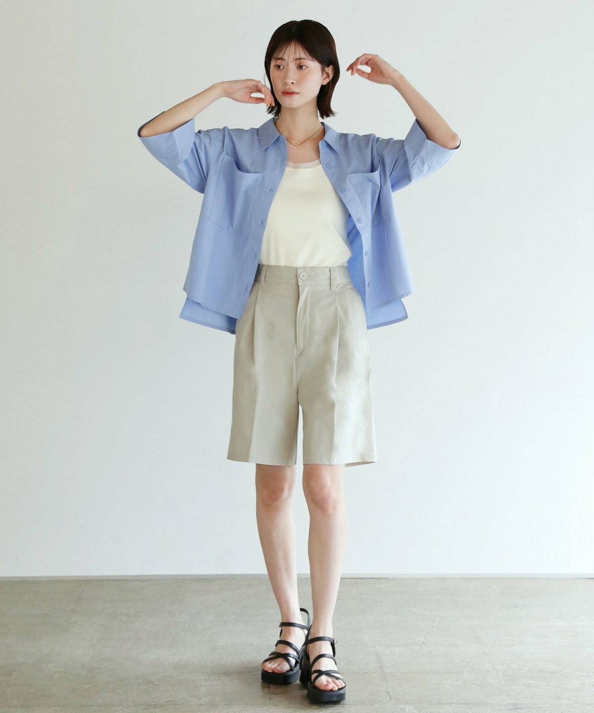 Tシャツにシャツを羽織ってハーフパンツを合わせた女性