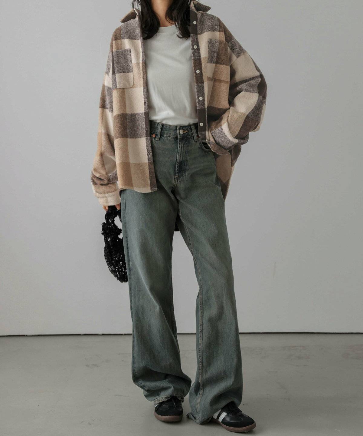 チェック柄シャツにデニムを合わせた女性