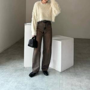  白ニットにデニムパンツを合わせた女性 