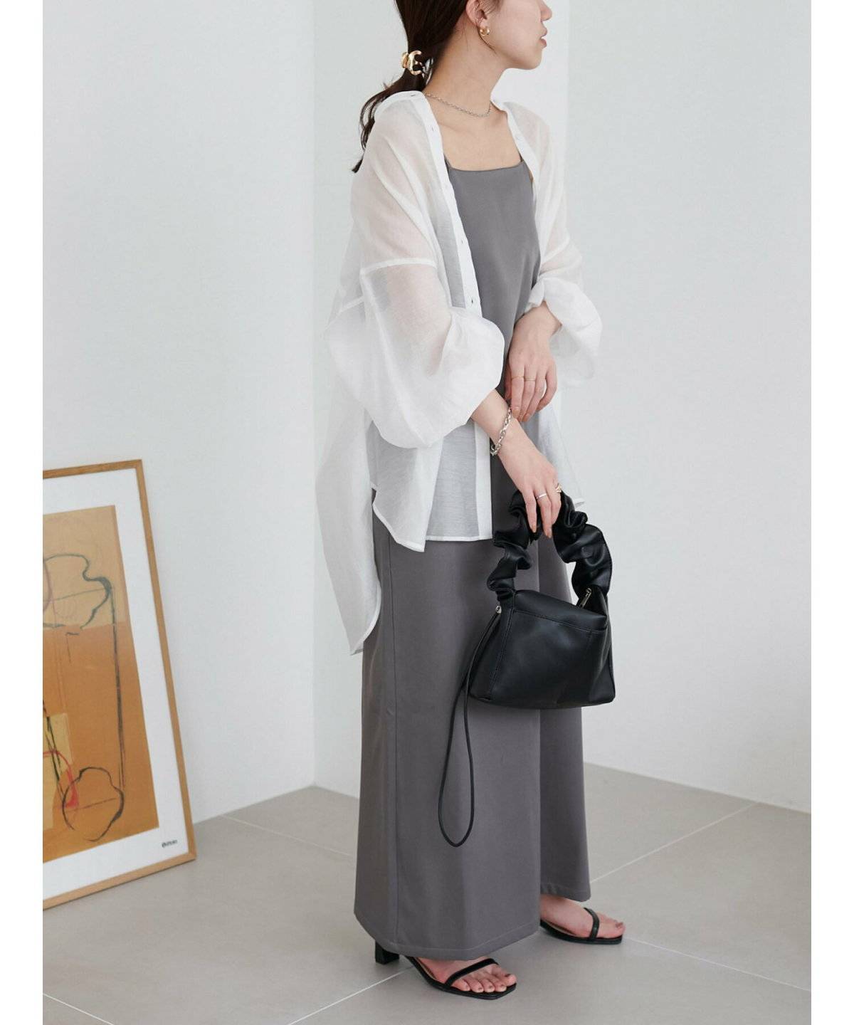 シャツとキャミワンピースを合わせた女性