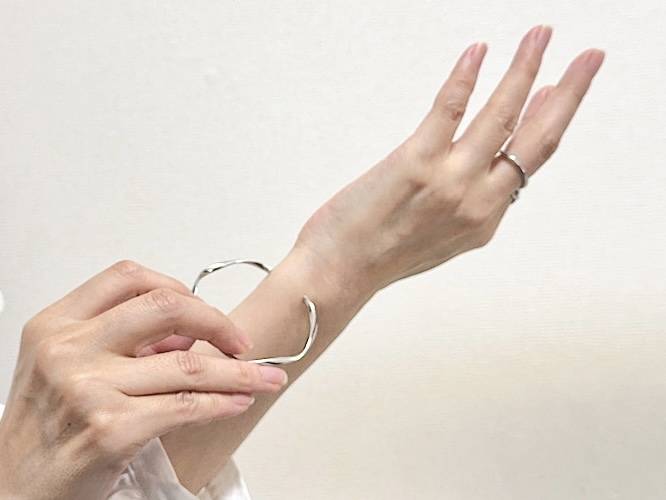 ブレスレットを腕にはめる様子