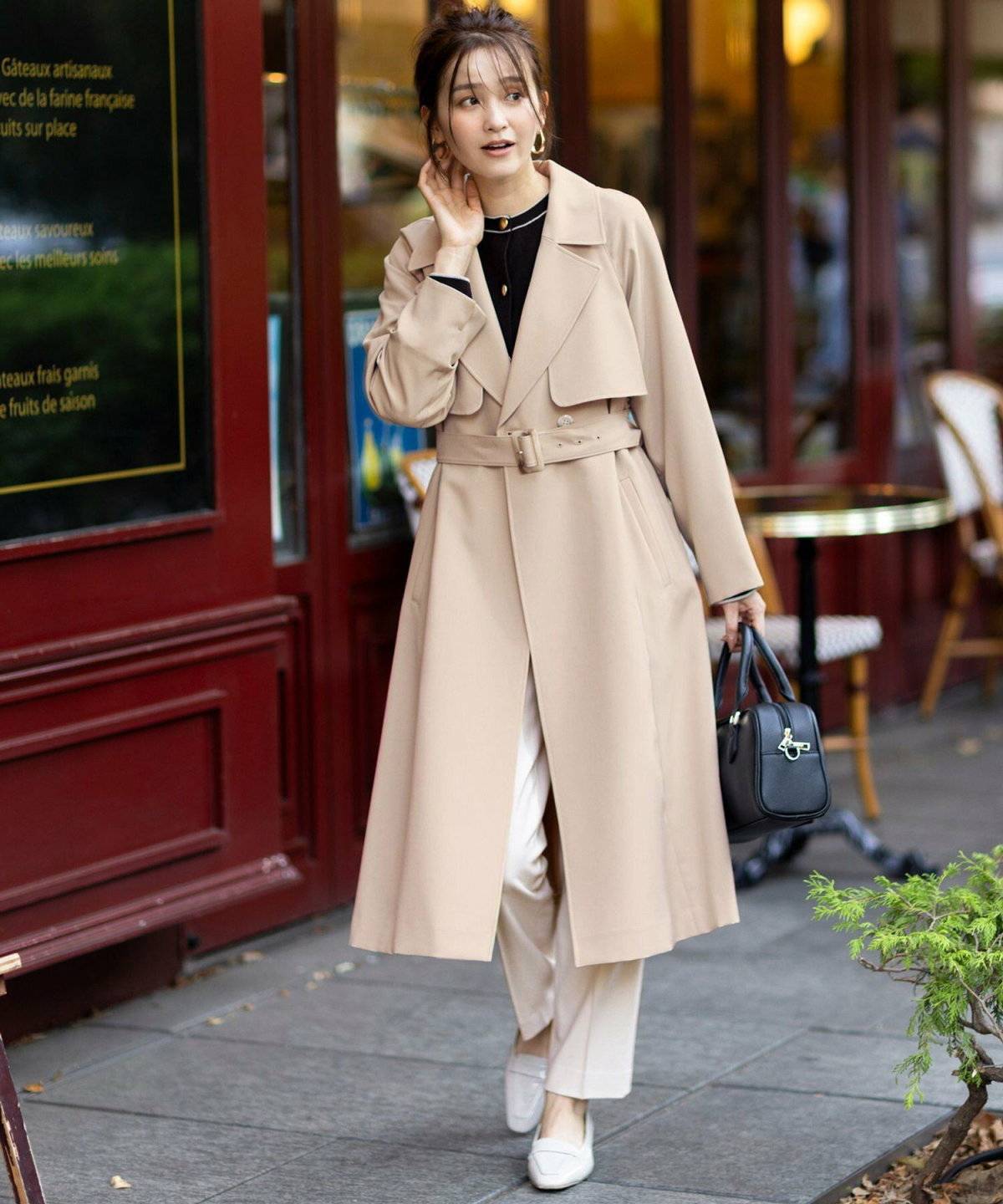 白トレンチコートにパンツを合わせた女性
