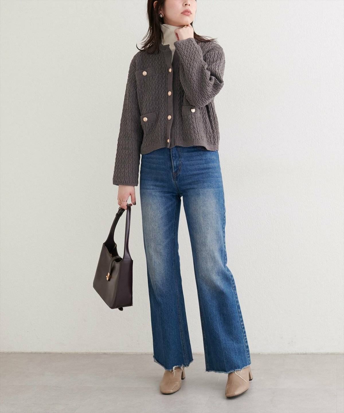 カーディガンを羽織ってデニムを合わせた女性