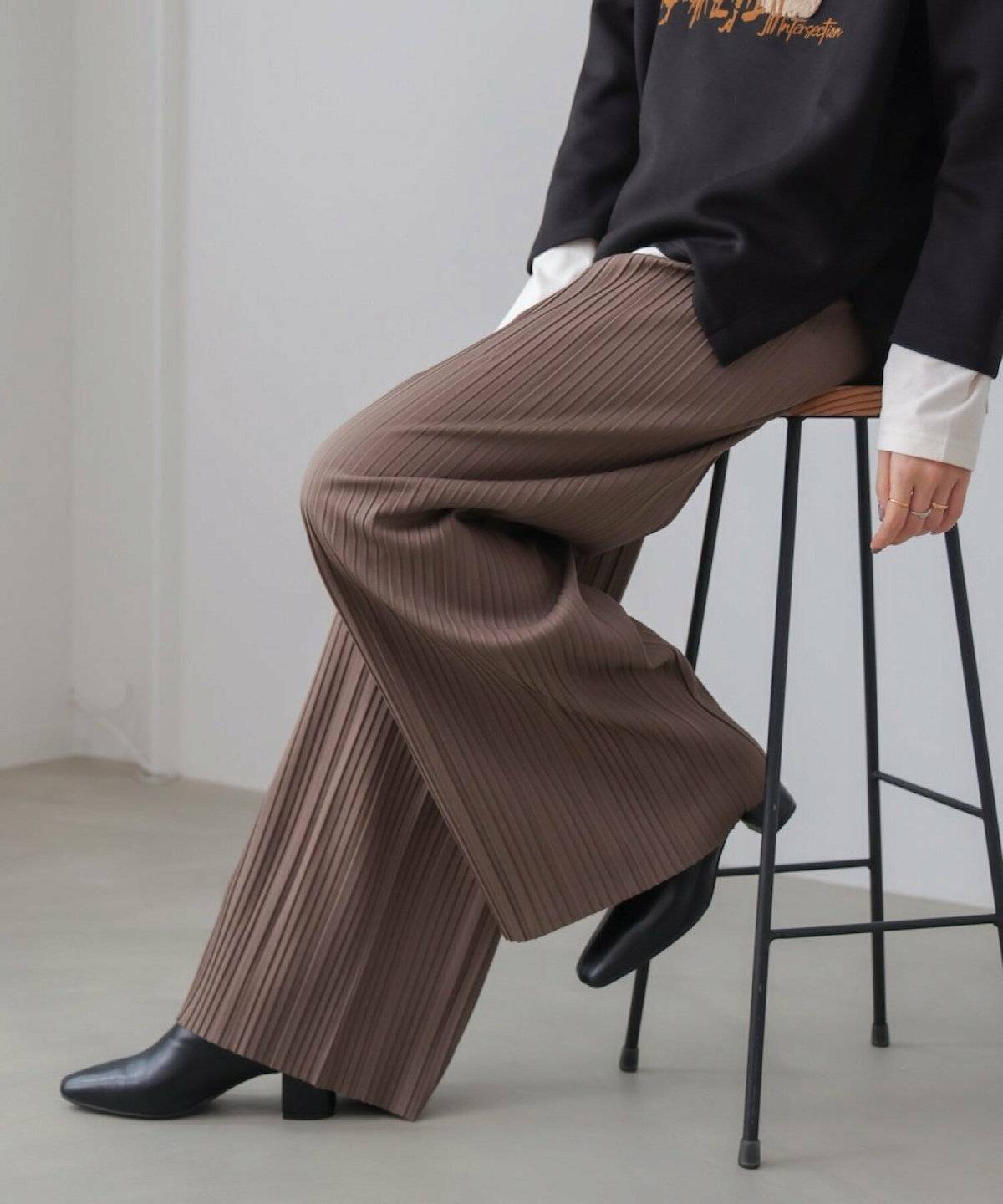 ベージュのスウェットにブラウンのパンツを合わせた女性