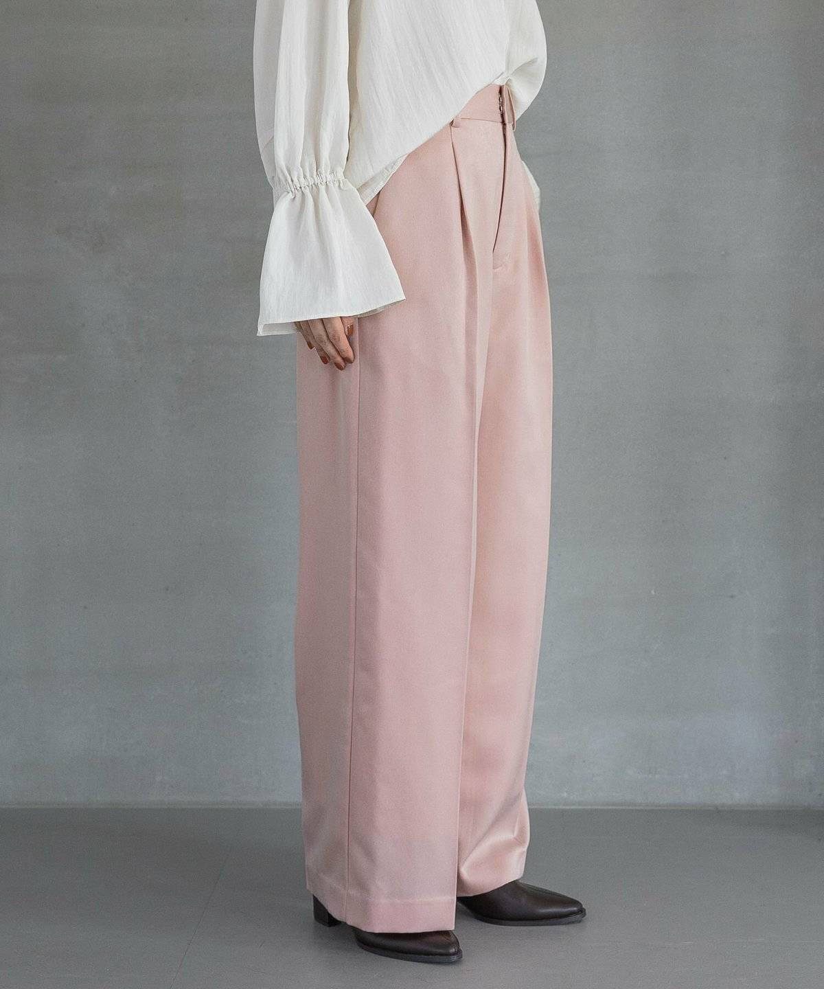 白ブラウスにピンクパンツを合わせた女性