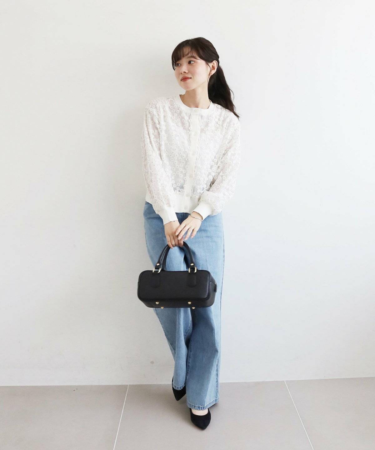 レースカーディガンにデニムを合わせた女性