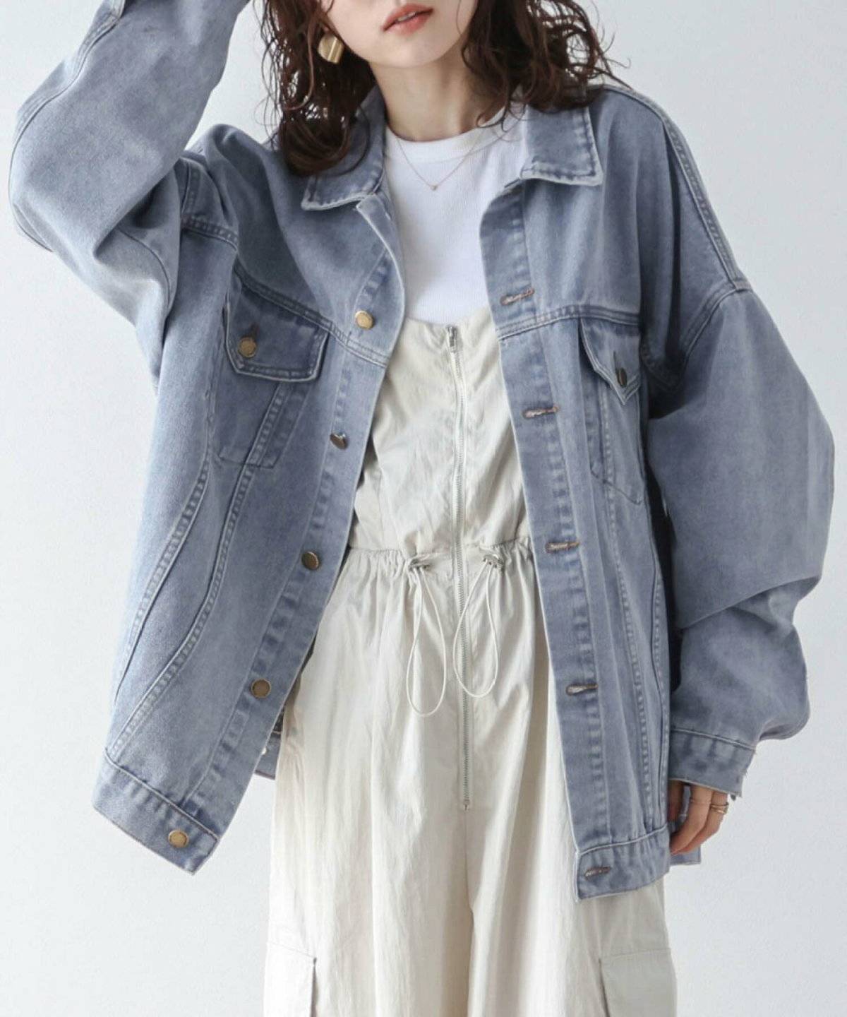 白サロペットにデニムジャケットを羽織った女性