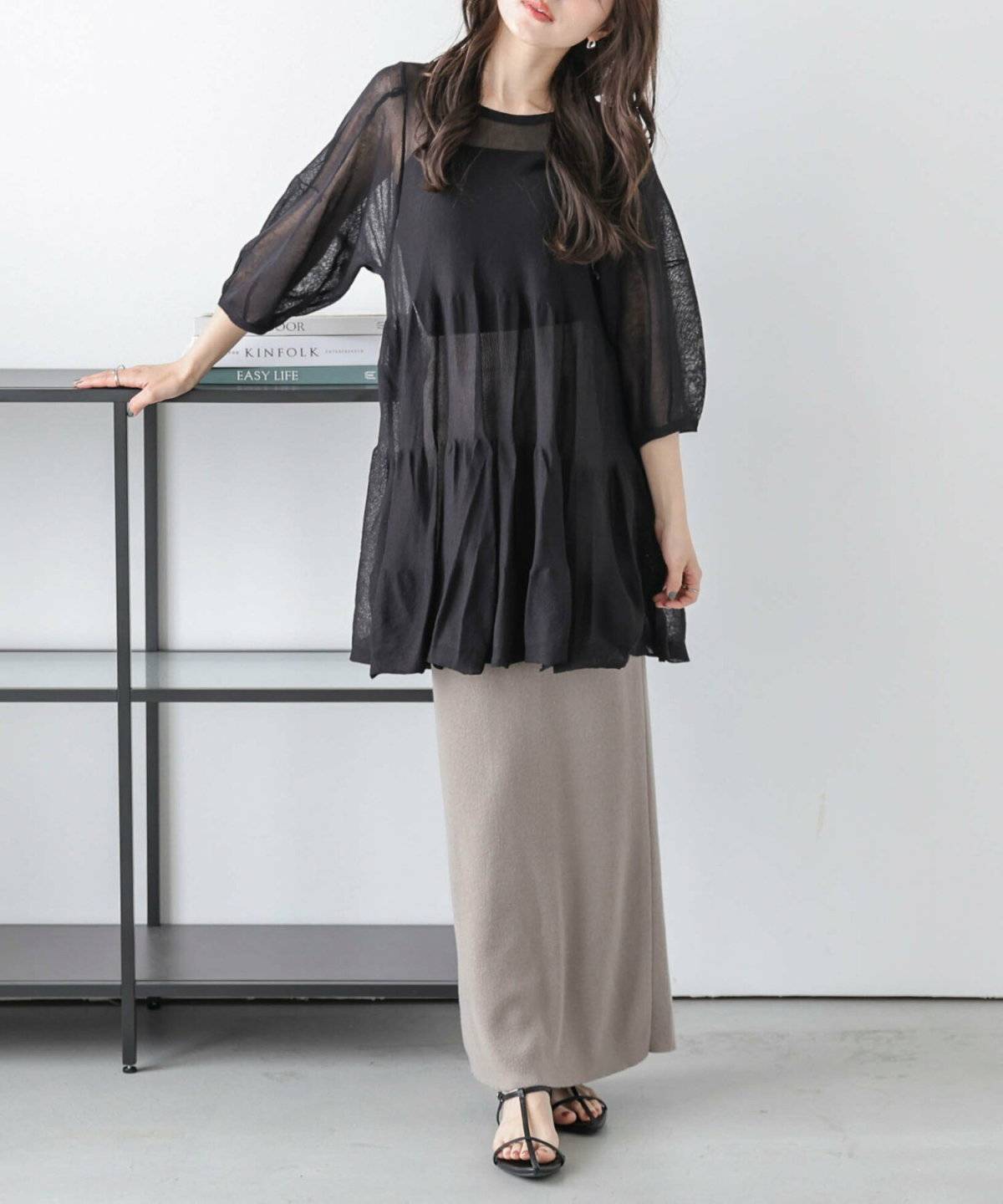 シアーチュニックとスカートコーデの女性