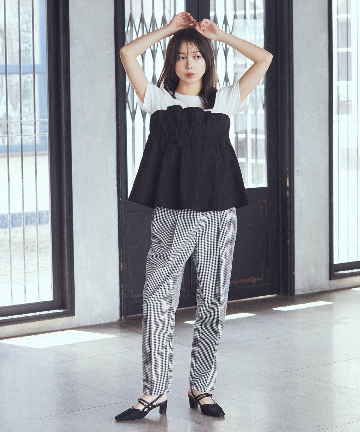 レイヤード風トップスに柄パンツを合わせた女性