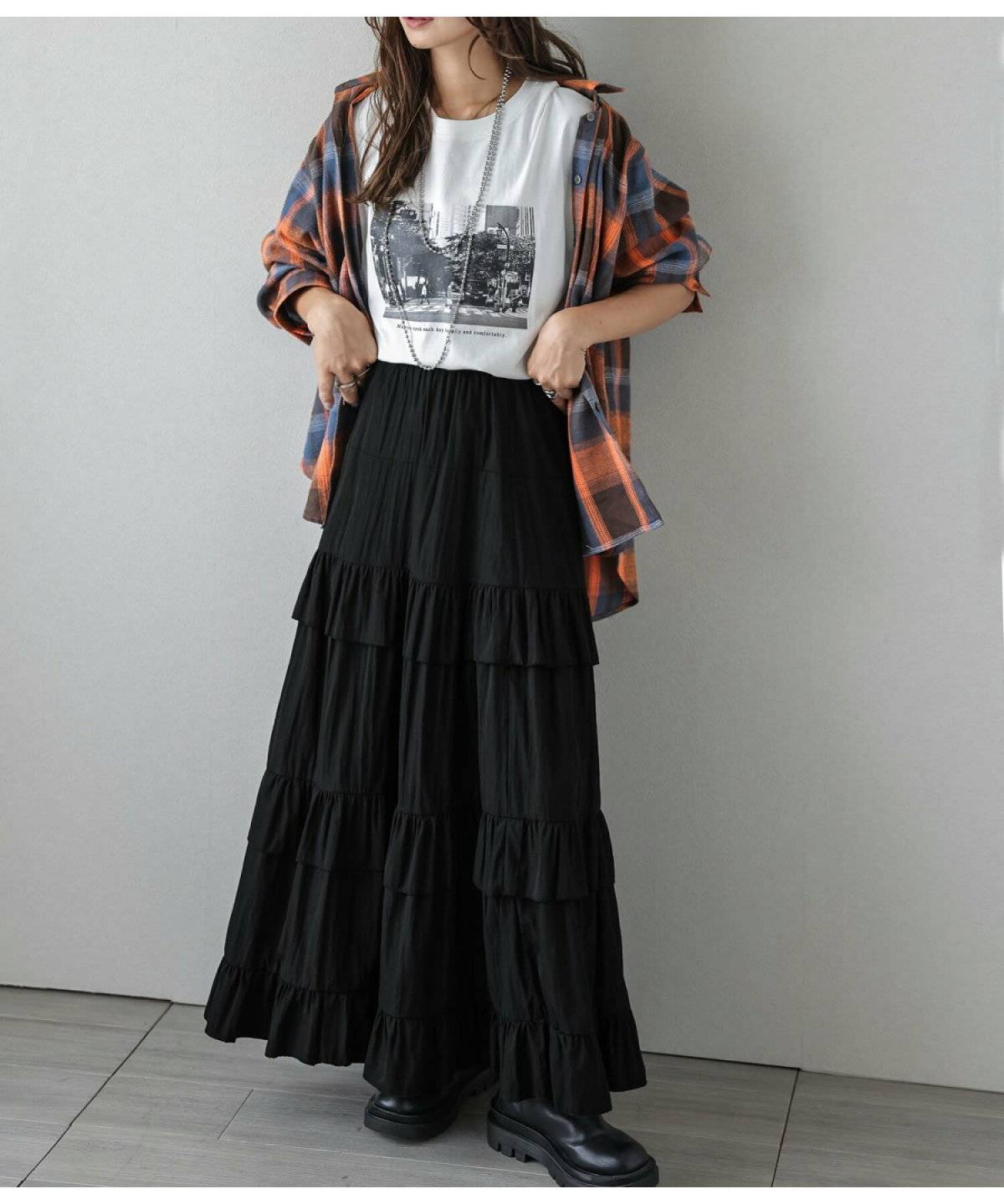 グレーのTシャツに黒スカートを合わせた女性